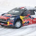 a rally car driving on a snowy road
