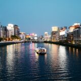 white boat on river near city buildings during daytime